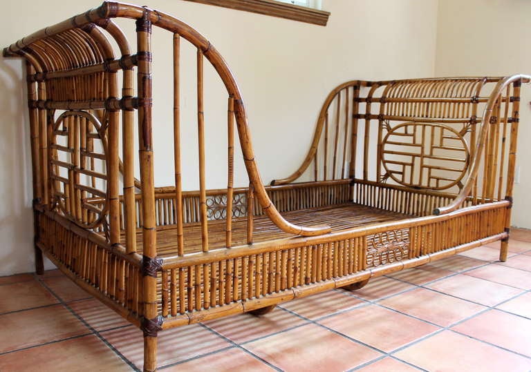 1960's Rattan Sleigh Bed or Daybed. Perfectly maintained with very beautiful coloring and vintage characteristics. Chinese chippendale fretwork on head/footboard. Bottom of bed has stick rattan running horizontally and thicker rattan running