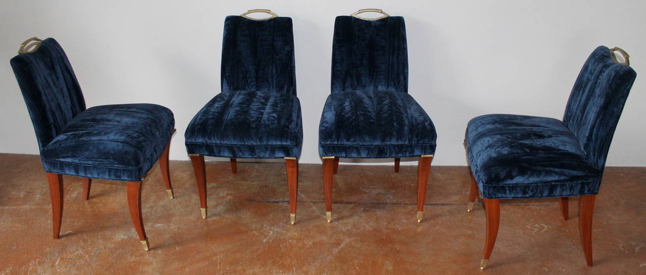 Set of four Arturo Pani dining chairs.
Mexico, 1950s.
Mahogany frame and legs topped with brass fittings. Chairs have been reupholstered in a fine navy blue vintage crushed velvet.

