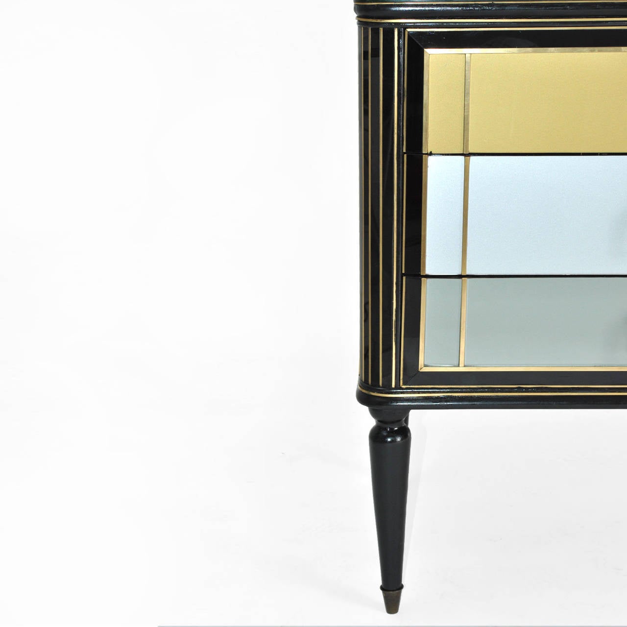 Commode composed by six drawers, made in solid wood, covered in Murano Glass in different colors, finished in brass and legged in black lacquer turning form.