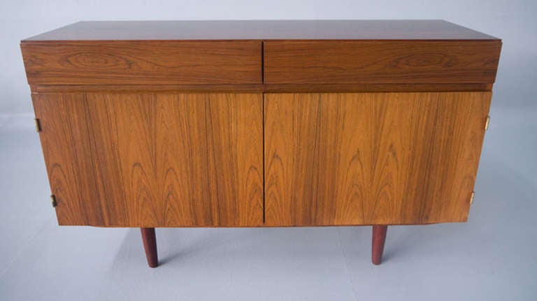 A compact version of the iconic Kofod Larsen rosewood sideboard. With the exceptional rosewood grain you would expect. The finish is in equally impressive condition. The case holds two solid oak, dovetailed drawers. Below are two cabinet doors