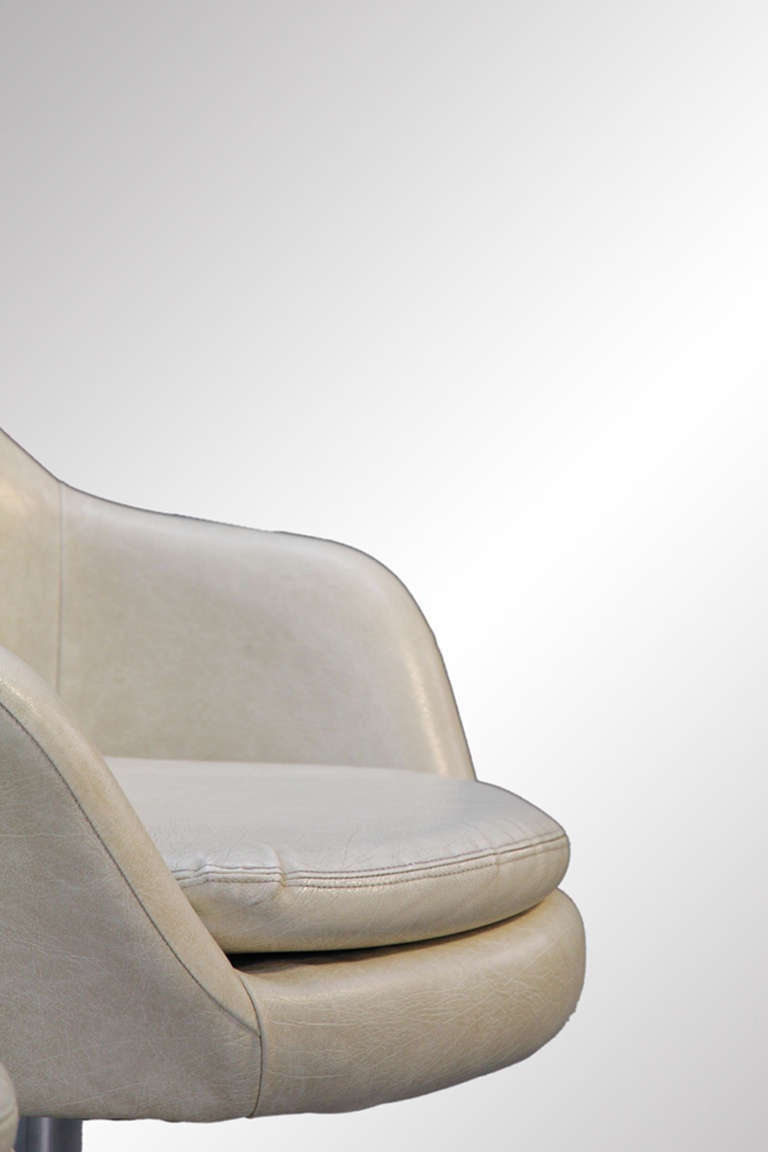 Offered are a stylish set of swivel arm chairs from Sweden. The white vinyl upholstery is in very good condition. The cushioned seat is removable and has a zipper bottom for easy replacement of the foam when needed. They swivel on nickel plated four