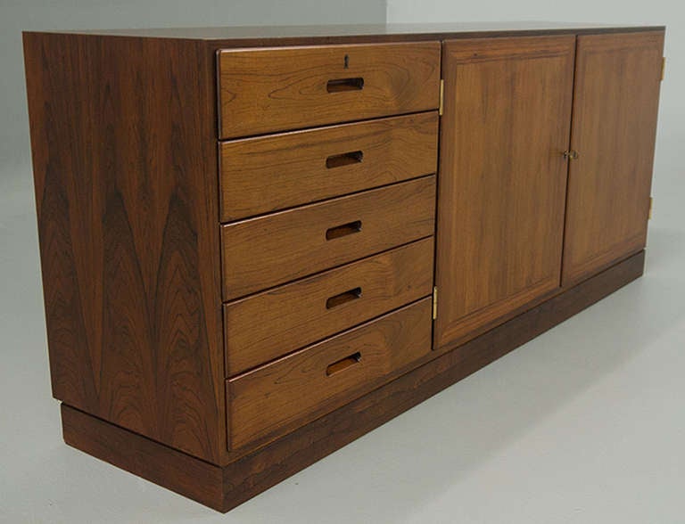 An absolutely stunning low profile rosewood credenza in superlative condition. The perfect form and model for the audiophile. Designed for stereo components in the mid century. Now a desirable element in the modern home for the flat screen tv. 