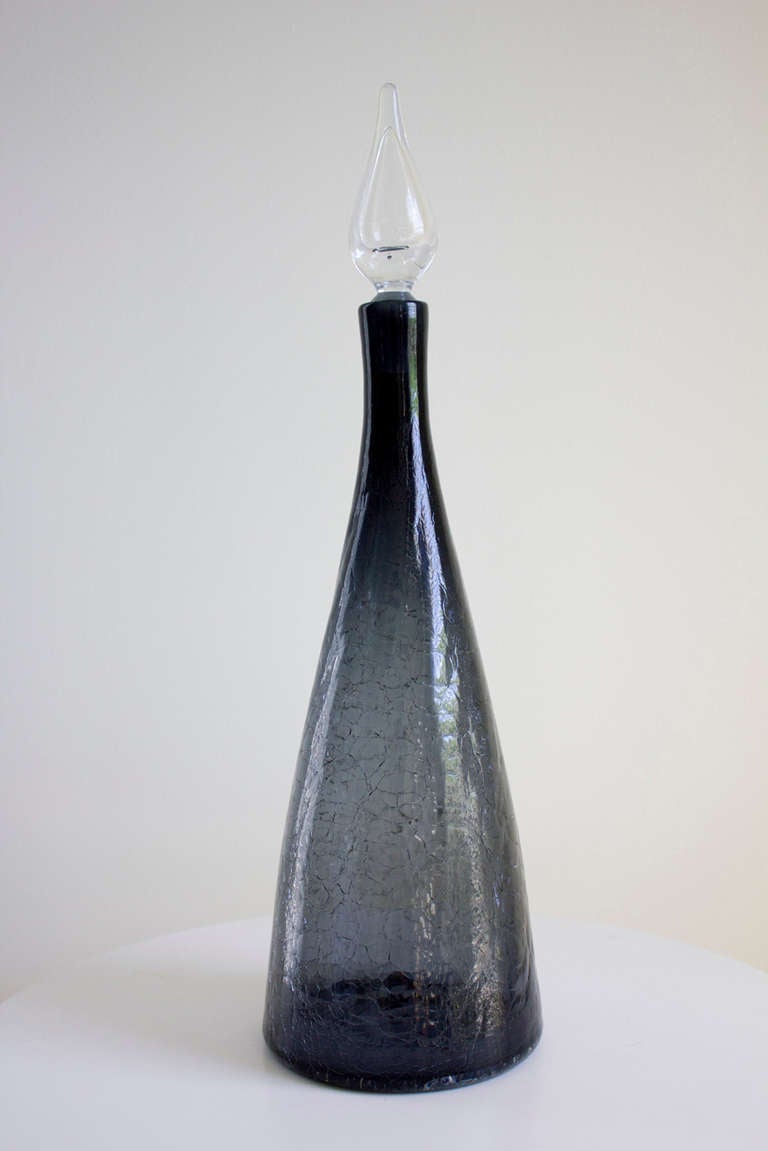 Blenko Decanter smoked glass.

Excellent vintage condition. The stopper does had a slight imperfection/chip on side. 

Dimensions: Decanter:
H 21.25 (54cm).
D 6.25 (15.9cm).

Stopper: 
H 6.25 (15.9cm).