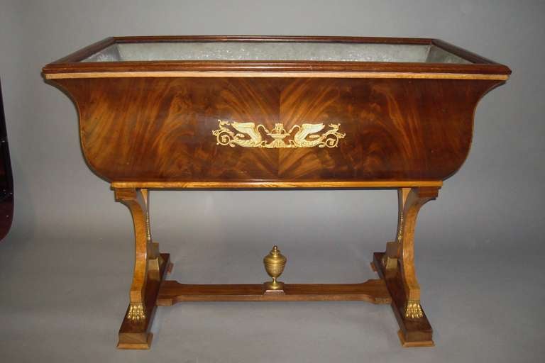 An impressive C19th Danish mahogany and burr elm jardinere/wine cistern, the rectangular top with a moulded edge with burr elm cross banding below; above a flared body veneered in well figured flame mahogany; with classical ormolu mounts depicting