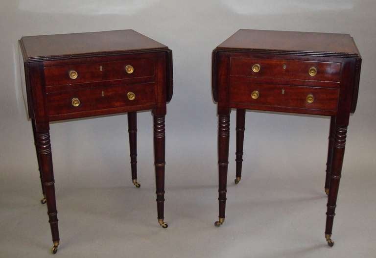 A rare pair of Regency mahogany small pembroke tables; the well figured tops with rounded corners to the flaps of either side all with a reeded edge, with two shallow drawers below with oak linings, the top drawer having adjustable divisions with