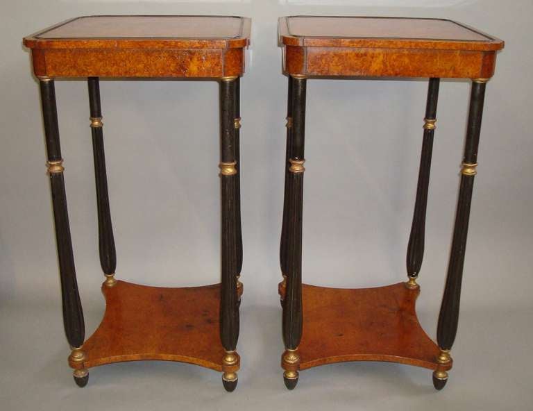An elegant pair of rare Regency amboyna occasional tables; the  square top with re-entrant corners and incorporating ebony raised cockbeading; the shallow frieze also with re-entrant corners; raised on turned and fluted ebonised supports, each with