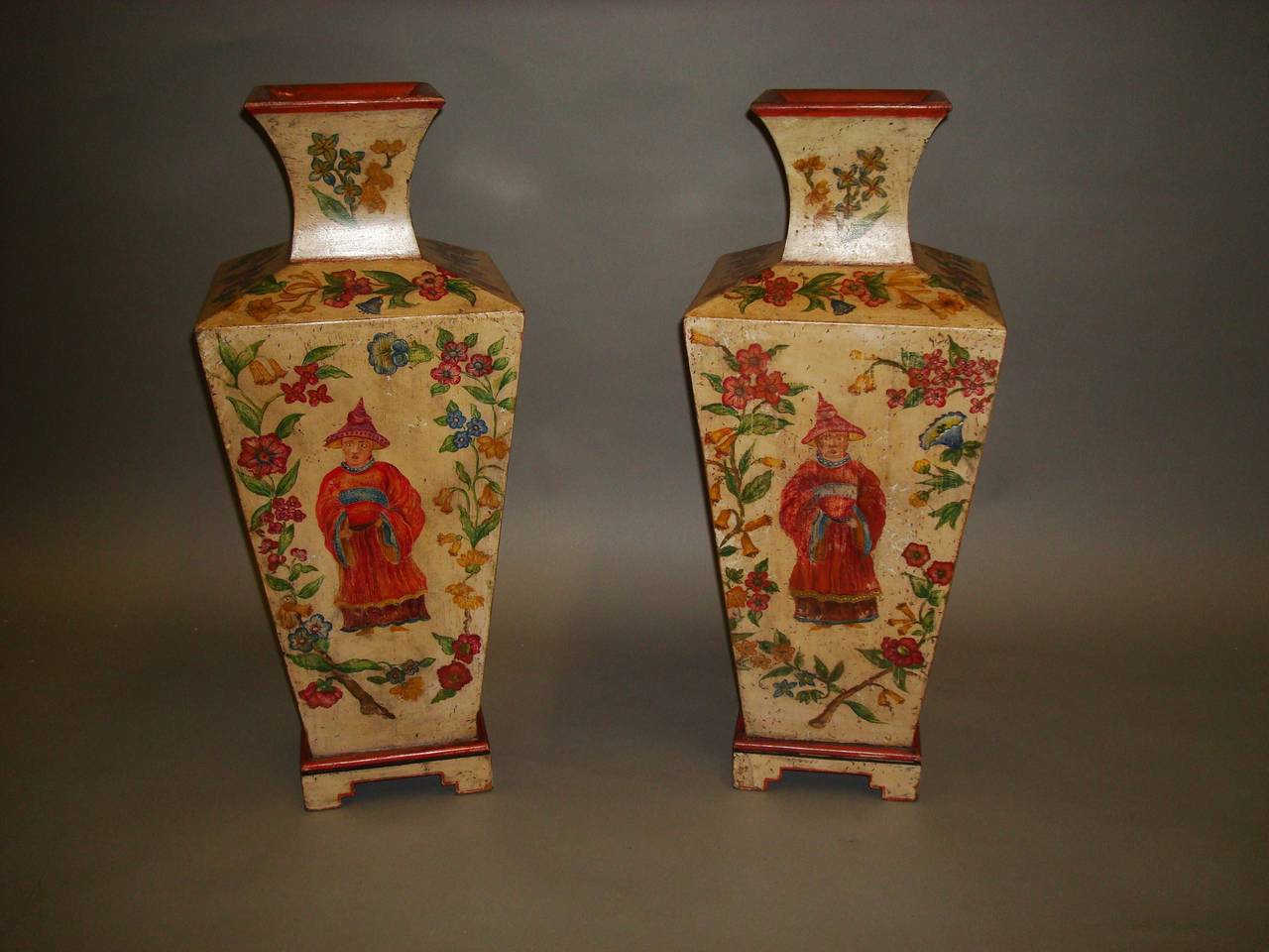 Early 20th century decorative pair of large painted pine vases; the flaired neck above the square tapering body profusely decorated with brightly painted trailing flowers and foliage on an ivory coloured background, each panel depicting a different
