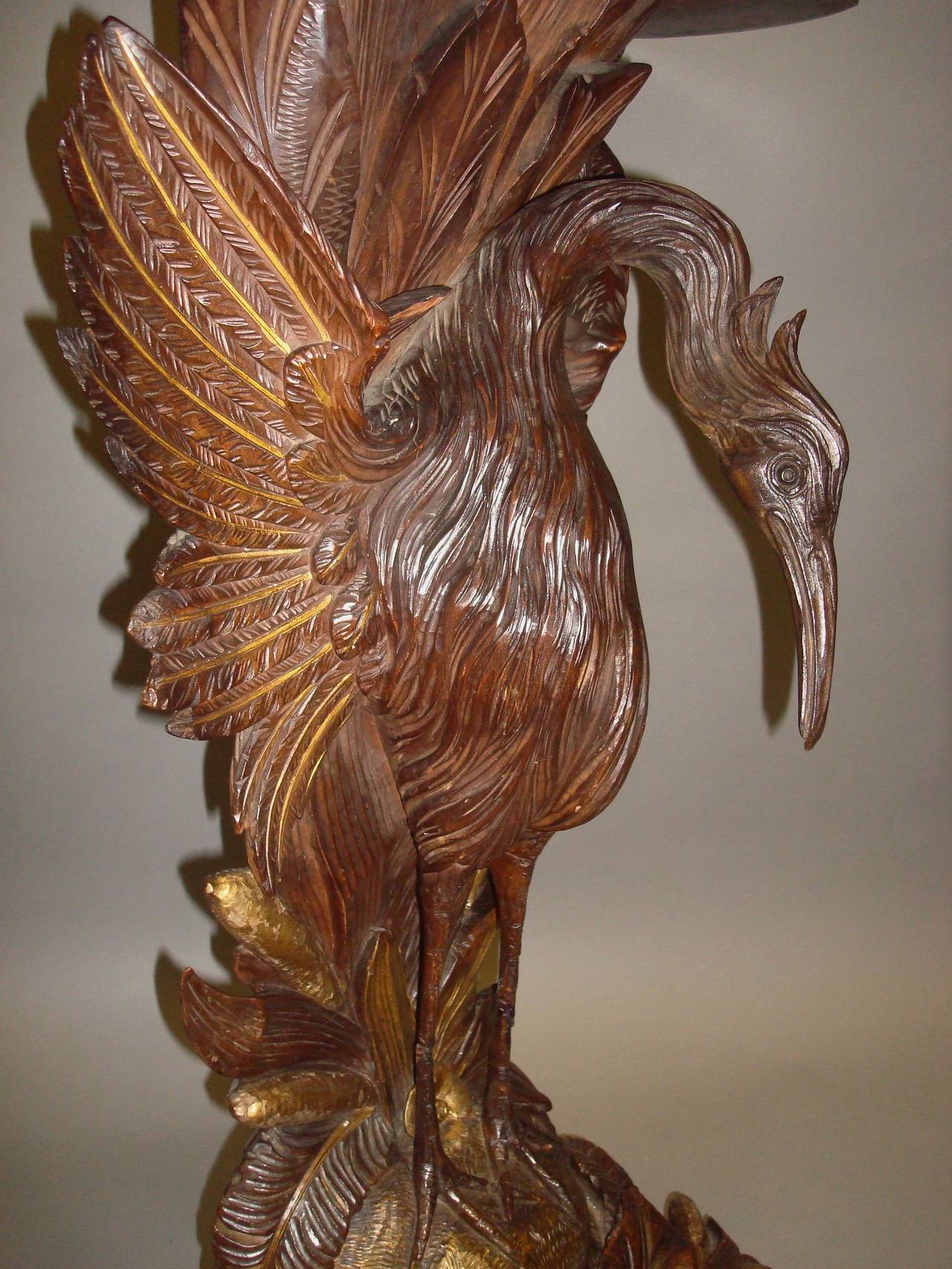 A good 19th century carved walnut and gilt 'heron' console table; the well figured shaped top with a carved and partially gilded flowerhead moulding above a carved leaf and gilt bullrush apron raised on a finely carved large heron with spread wings,