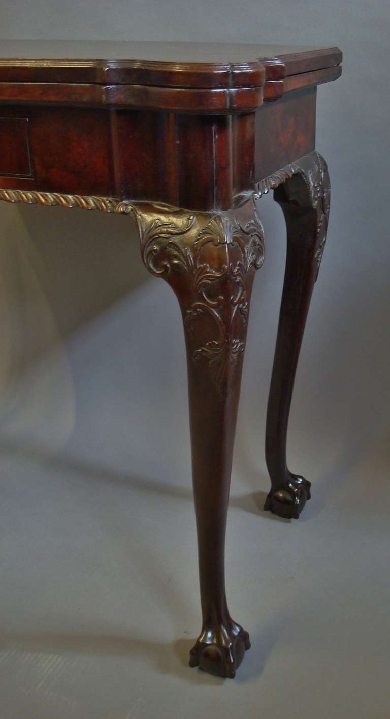 An exceptional George III mahogany card table, the well figured fold over top with a fine reeded edge mould of exaggerated shaped form with re-entrant corners, revealing a baize lined playing surface with crossbanding echoing the shape of the top,