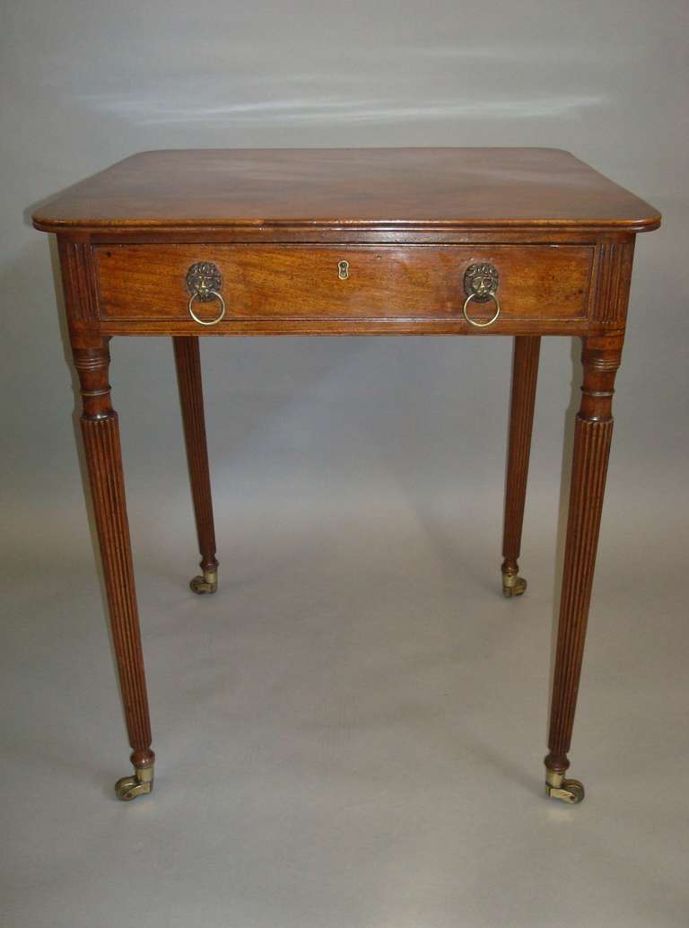 An elegant Regency Gillows mahogany side table, the very well figured rectangular top with rounded corners and a reeded edge with frieze drawer below having a mahogany drawer lining with a pen and ink  division and a cockbeaded edge; with later