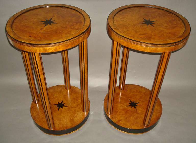 A smart pair of burr elm and ebony occasional tables; the circular tops with a wide raised border edged with ebony mouldings; the central panel being quarter veneered in burr elm and inlaid with a large ebony star; the stepped frieze supported on