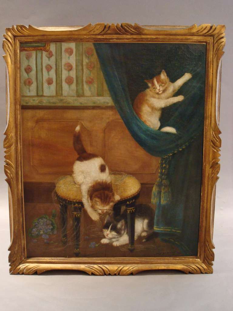 An amusing oil painting of cats consisting of three cats mischievously playing in a room interior. One climbing a velvet curtain, and two others playing with a spool of wool around a stool. The background incorporating a panelled wall with floral