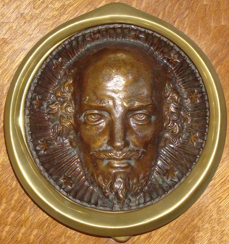 A large C19th bronze 'Shakespeare' door knocker of circular form, the deep relief centre depicting William Shakespeare's head with a ruffle collar incorporating flutes and stars with rich patination.  The outer with a circular hinged knocker. 