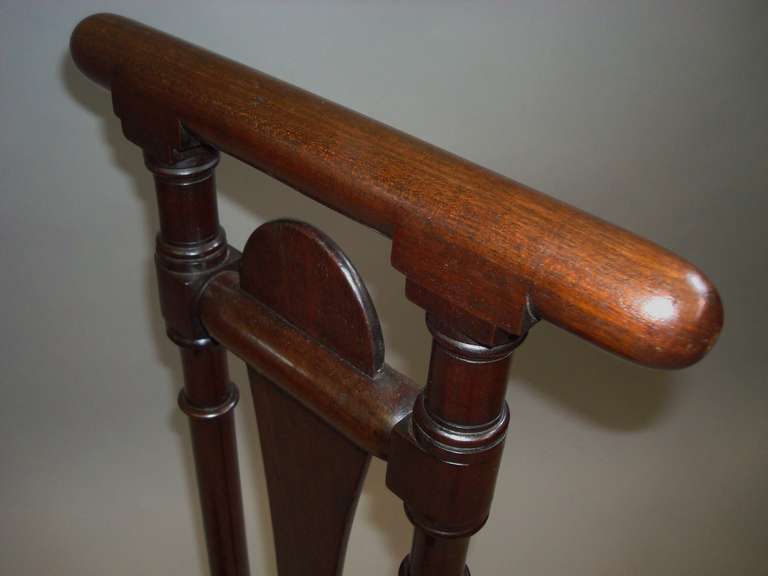 A Regency mahogany country house boot jack in the manner of Gillows; the turned handle supported on well turned supports centered with the shaped swinging arm on a rectangular base with rounded corners, raised on block feet. Good quality mahogany