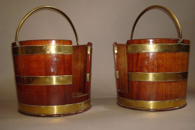 Rare pair of George III brass bound mahogany plate buckets; the slightly tapering form with three brass bands and brass swing handles. Lovely color.

With Provenance from Stancomb family, formerly of Blounts Court, Wiltshire and Barford Park,