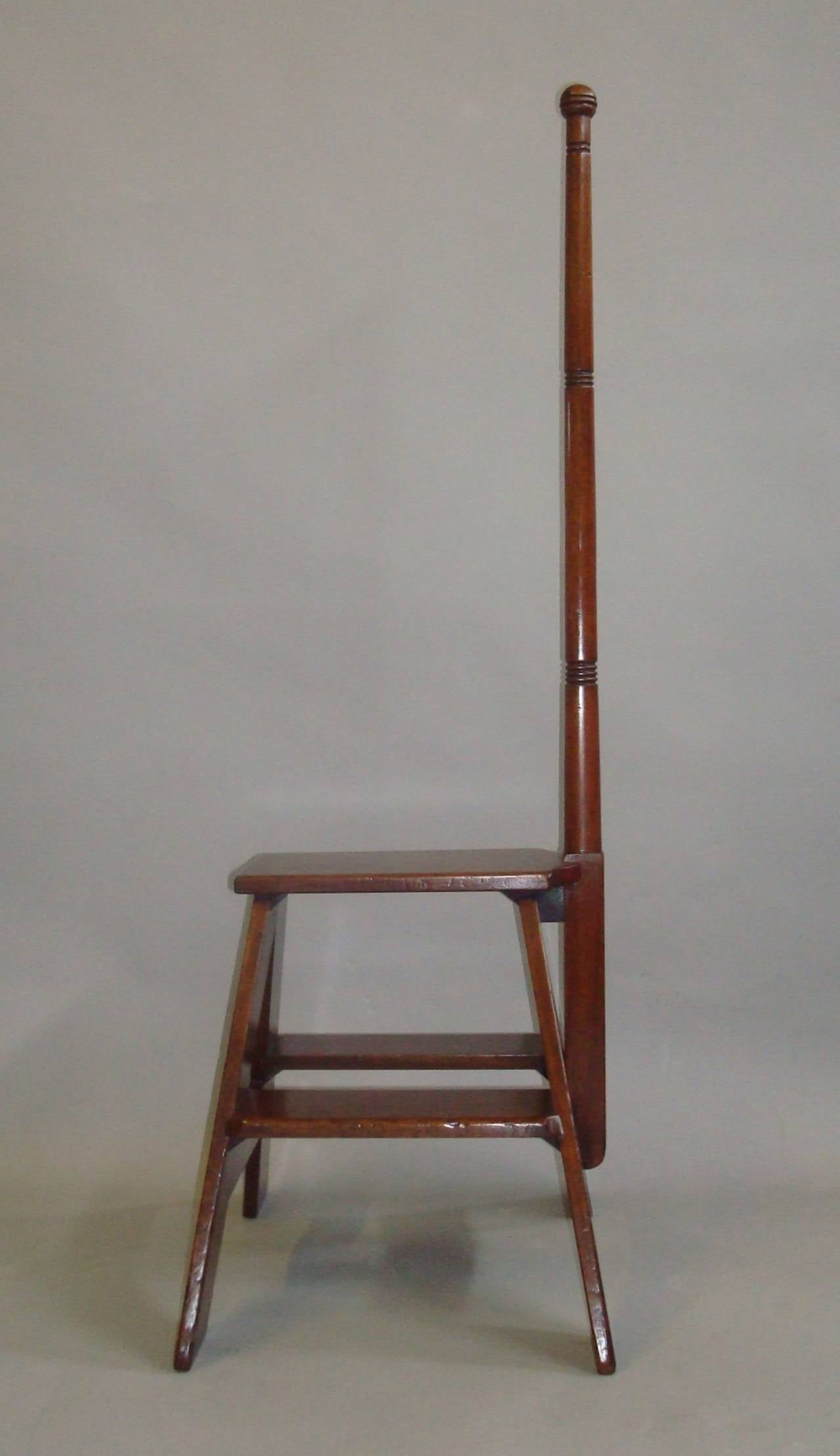 19th century set of mahogany library steps, freestanding and of small proportions; the raised tapering pole with ring turning and a ball finial; the central top step raised on  'A' frame supports with a single step to either side.