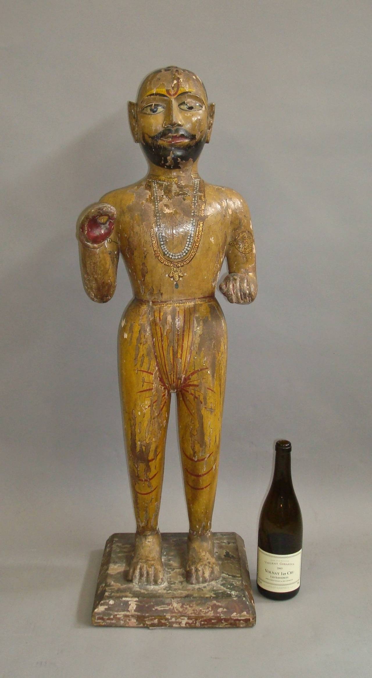 An interesting 19th century carved Indian figure; of a standing Indian man in traditional dress with his arms raised; with its original colourful polychrome decoration.  He was probably an advertising figure for a shop. .