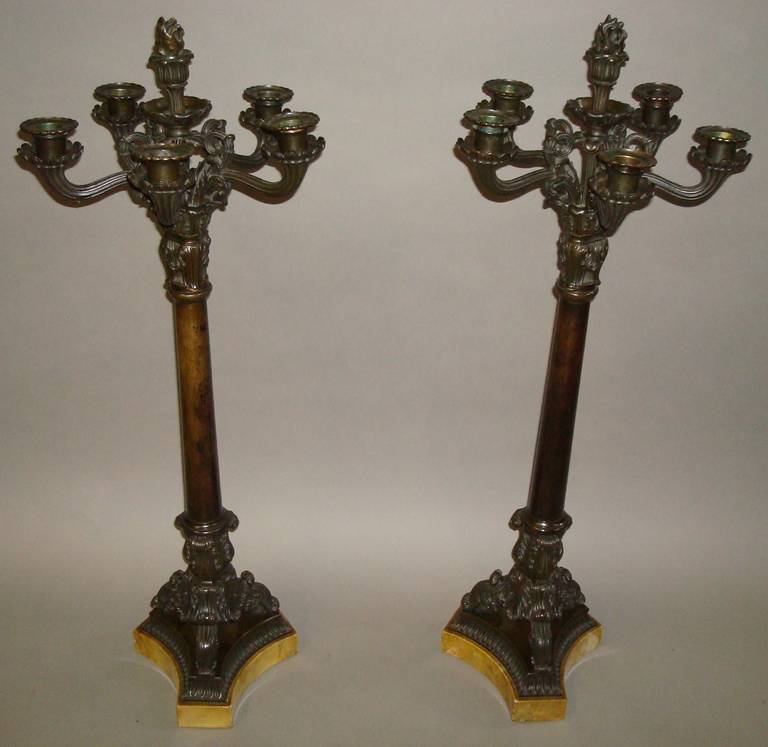 A good pair of Charles X bronze candelabra of large proportions. The central stem with foliate decoration and terminating with a flambeau removable candle snuffer. The five scrolled flowering stems with fluted branches leading to the candle sconces.