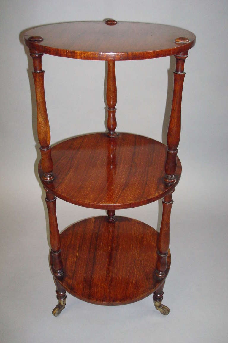 An elegant Regency rosewood, three tier etagere of unusual circular form.  The three tiers with three slender turned supports and slender turned legs, terminating in original brass castors.
Stamped 'Patent' with a crown.
Good condition and lovely