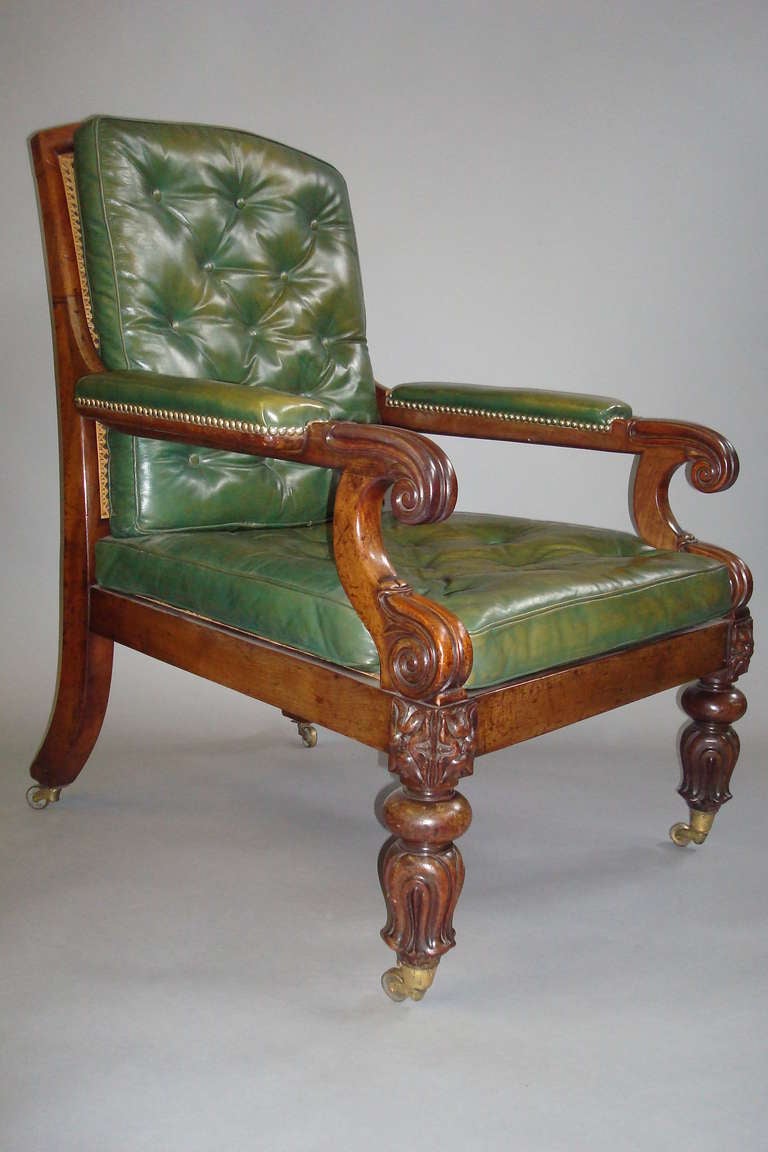 A good George IV mahogany and leather gentleman's library chair of generous proportions.  The caned back with an arched shaped top rail; the padded arms with carved scroll terminals and scroll arm supports.  The caned seat with carved paterae