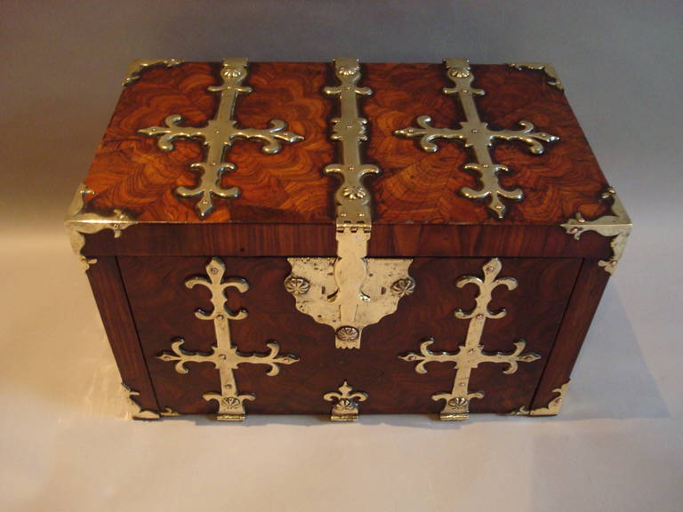 A late C17th oyster veneered kingwood and brass mounted coffre fort / casket; the rectangular top with book matched oyster veneers with heavy gothic brass strapwork hinges and central clasp; above a fall down front with similar brass work and a