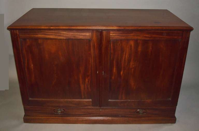 A George III mahogany Gillows folio cabinet / dwarf  press; the rectangular top with a moulded edge above a pair of panelled doors enclosing two oak sliding trays with a full length drawer below, incorporating the plinth with original sunken