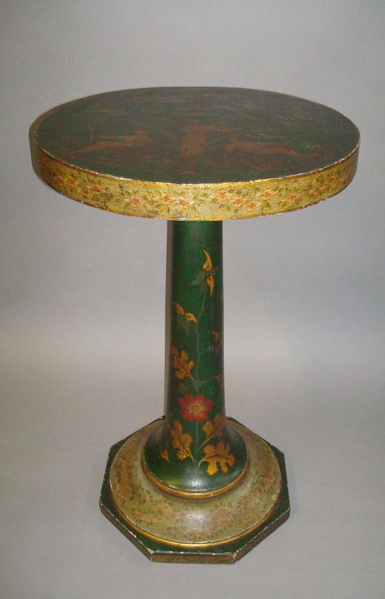 Mid-19th century French green lacquered occasional table, of unusual form; the thick circular top depicting Chinese figures catching butterflies; the edge with trailing foliage on a pale green background, raised on a trumpet column with gilt leaves