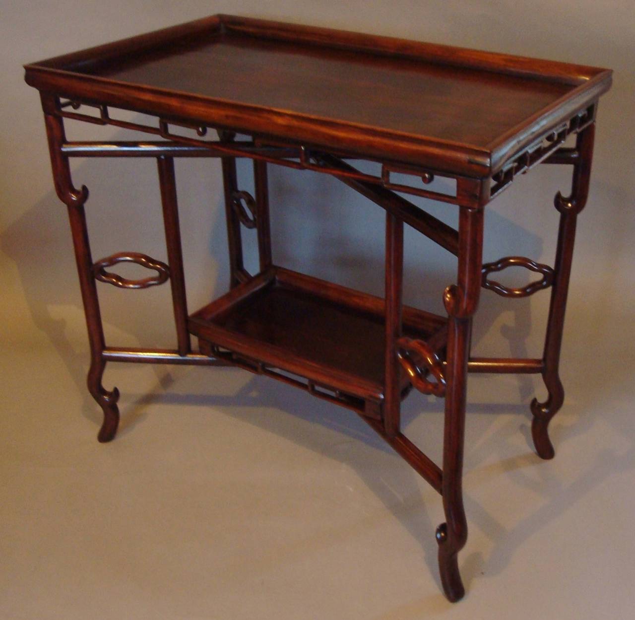 C19th Chinese Hongmu tray table; the removable rectangular tray top with a raised moulded gallery above an 'x' shaped base with scrolled legs, supporting a lower removable tray with a raised moulded gallery.  The two trays remove and the base is