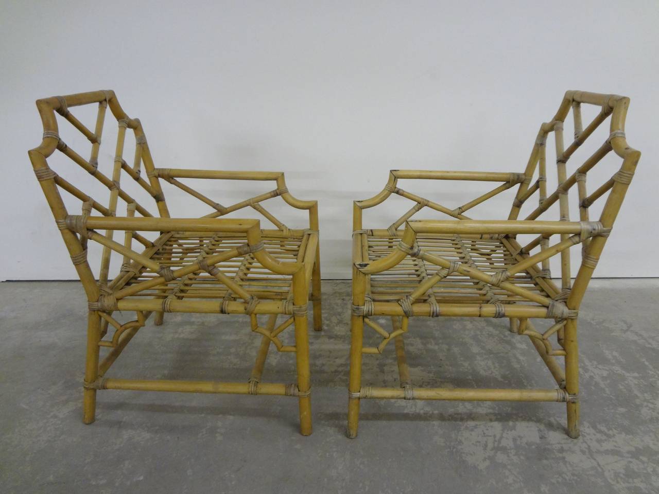 Pair of bamboo Chippendale armchairs, circa 1960s in excellent original condition. Cane strapping is tight and chairs are structurally sound. Ready for cushions of your choice.