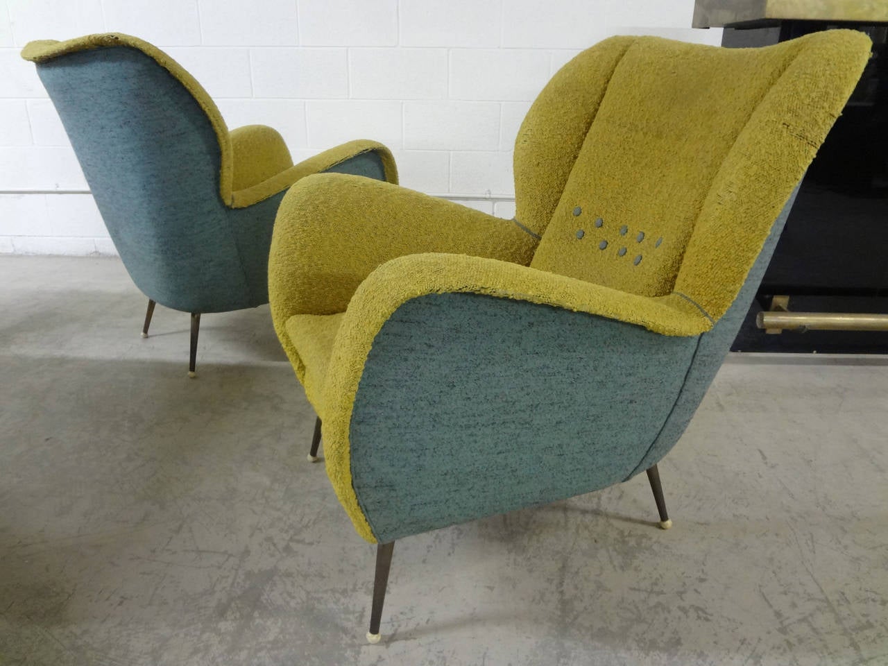 Stunning and sculptural, this pair of italian chairs, circa 1950's is the epitome of italian design. Brass tapered legs with white ball tips, dual color upholstery in italian wool boucle, and amazing comfort to boot! Chairs sport original upholstery