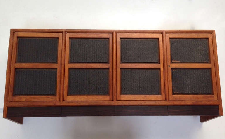 Very rare wall mounted cabinet in walnut by Edward Wormley's “Janus” series with four doors over four rosewood-front drawers as shown. Functions well as a buffet with suede lined drawer for flatware or as a dry bay. Antique Japanese printing plates
