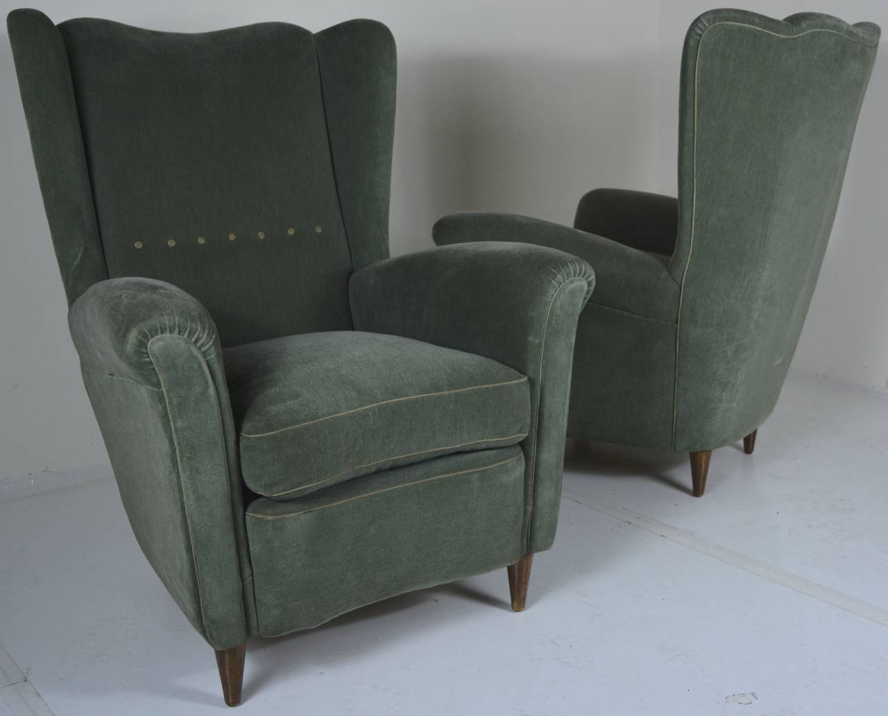 1940s pair of Italian lounge chairs in original olive mohair. Piping and button tufting to back appears to be in a rich silk blend. Down cushions and extravagant high back make for a statement. Subtle details and curves speak to a European old-world