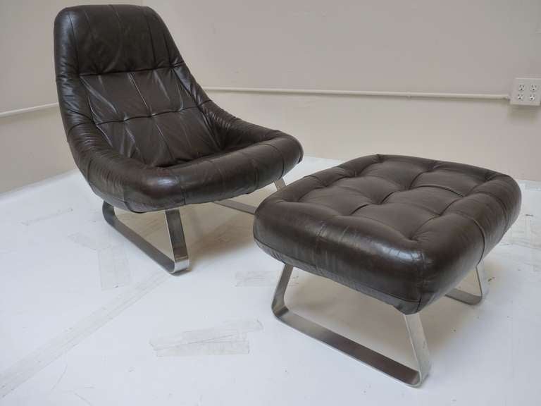 Earth Chair and Ottoman by Percival Lafer c.1970. Original brown leather is in very nice original condition and base displays heavy patina as shown. Base can be re-chrome plated for an additional fee.
