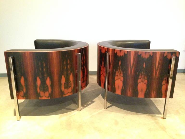 Pair of Barrel Chairs by George Kasparian in black leather and brazilian rosewood. Each chair has 4 chrome legs and leather work is top-stitched with top-grain leather. Each chair retains maker's label. Chairs are of larger than usual scale for
