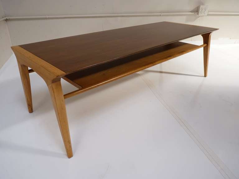 As a sculptural cocktail table, this walnut table by John Van Koert's Profile Line for Drexel is quite stylish and sophisticated. It features a dark walnut top, light walnut shelf, and bleached walnut hued legs for bringing together any room with