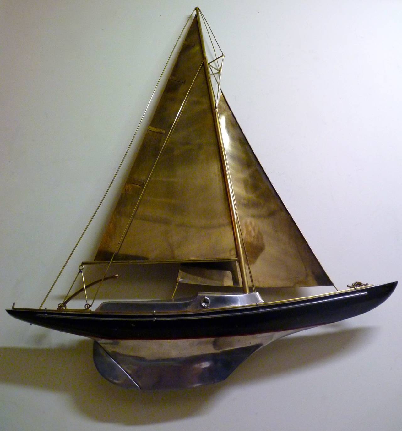 Sailboat wall sculpture by Curtis Jere in cast aluminum and patinated brass. This piece is signed as shown and dates to the 1980s. This particular Jere sculpture is likely the highest quality construction of any Jere sculpture that I have seen yet.