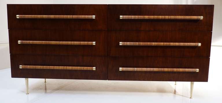 T.H. Robsjohn-Gibbings for Widdicomb six-drawer dresser in dark walnut with satin brass legs and hardware. Drawer pulls are wrapped with original caning in excellent condition. Wood grain has beautiful figuring as shown and drawers have multiple