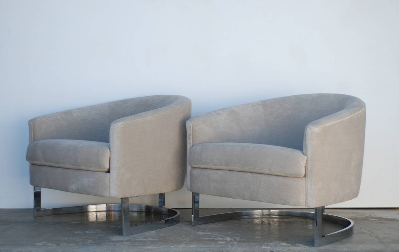 These barrel back lounge chairs have been reupholstered with back detailing accentuating the T-back. The fabric is a gorgeous light oyster grey velvet. 
The base is nickel over steel and is in excellent vintage condition.