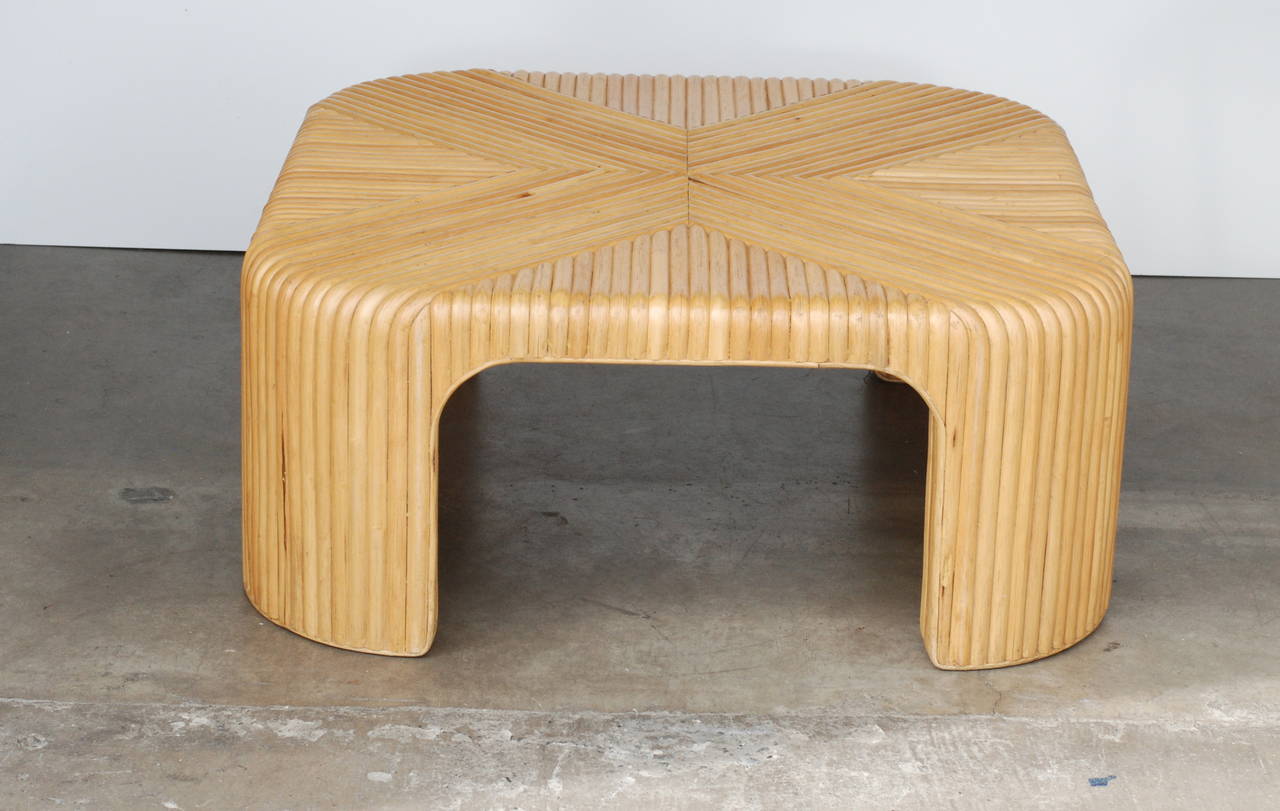 This low sleek graphic rattan coffee table. The rattan has been shaped into X-pattern which curves seamlessly down the legs of the table. It is beautifully made.