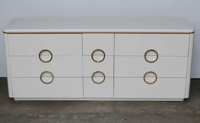 A six drawer vintage dresser manufactured by Mount Airy Furniture Co.
It has been finished in a bone off white color to offset the original brass handles which have a Gucci-esque style.  
We have a matching nightstand in a separate listing.