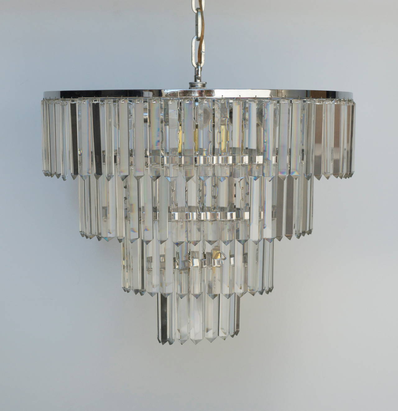 A beautiful vintage chandelier in excellent condition with four tiers of glass prisms mounted on a mixed metal frame of chrome with brass fittings.
There are six Sputnik lights and six hanging light for a total of 12 lights in all. There is 17