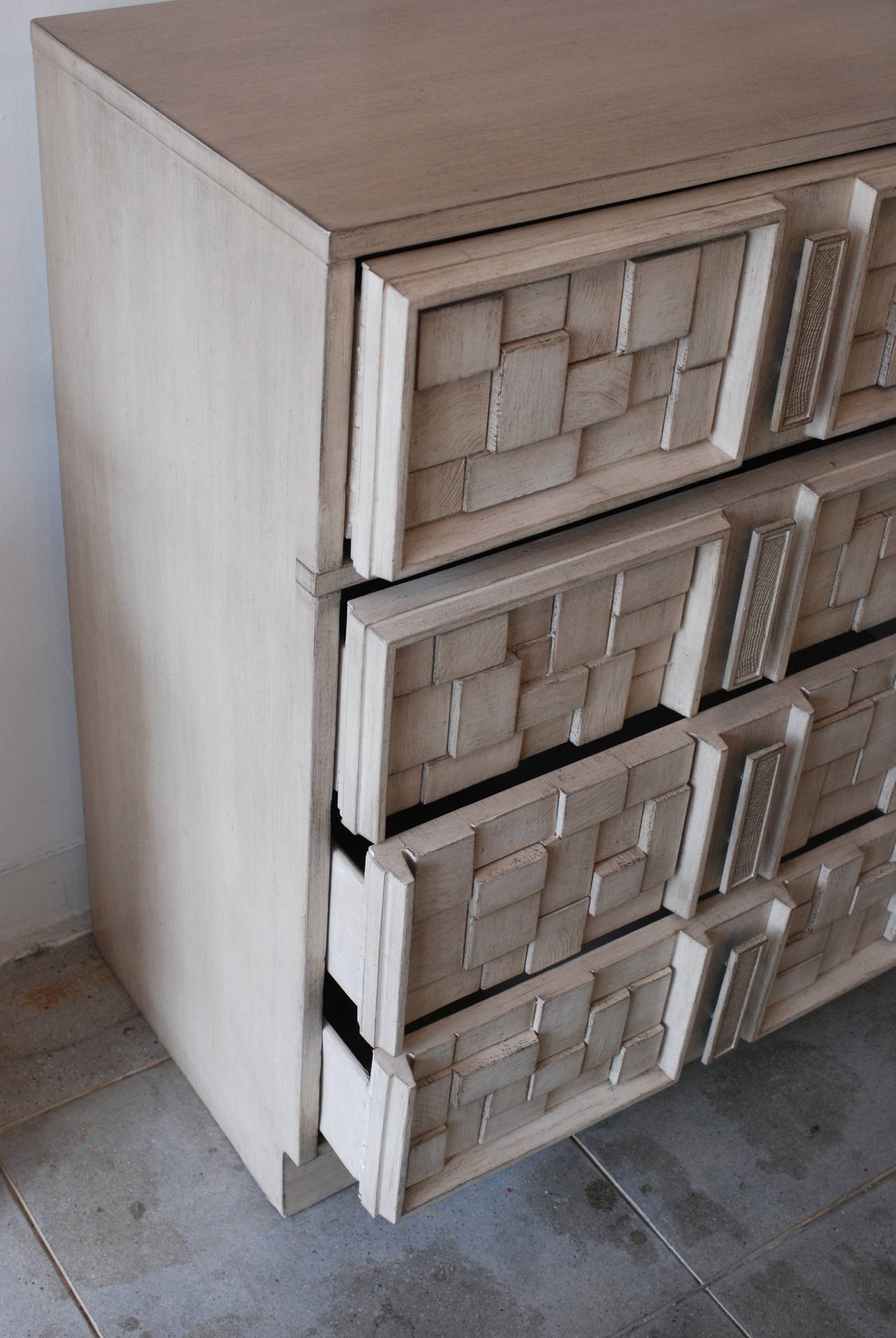 In the style of Paul Evans and Lane Furniture this hi-boy dresser has been refinished in our signature 'driftwood' finish that accentuates the relief work on the fascia of the drawer faces. The integrated custom hardware drawer pulls 
give this