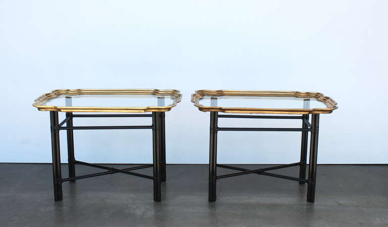 A pair of side tables with removable brass trimmed glass trays that rest on metal faux bamboo bases which have been recently refinished in a satin black.