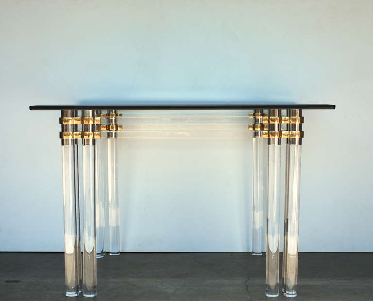 This 1970s era twelve leg lucite brass and nickel table has a vintage square glass 42