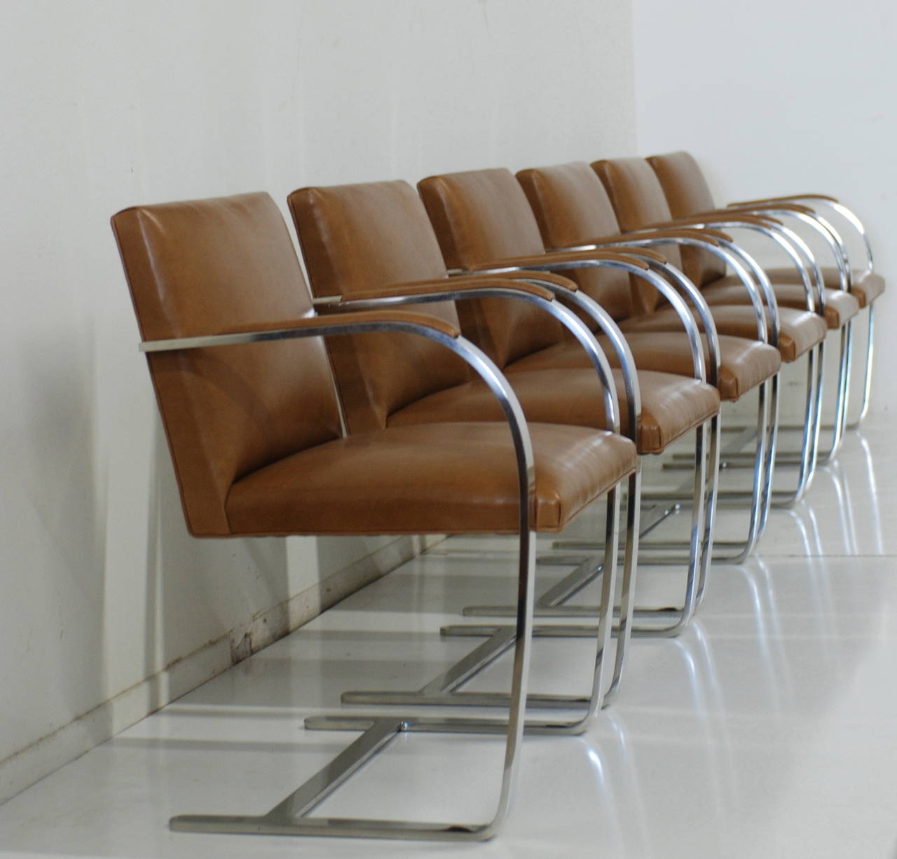 These vintage Classic Ludwig Mies van der Rohe designed Brno chairs have been expertly reupholstered in a caramel colored leather. These are substantial, heavy and in excellent vintage ready to go condition. The height of the arm is 26
