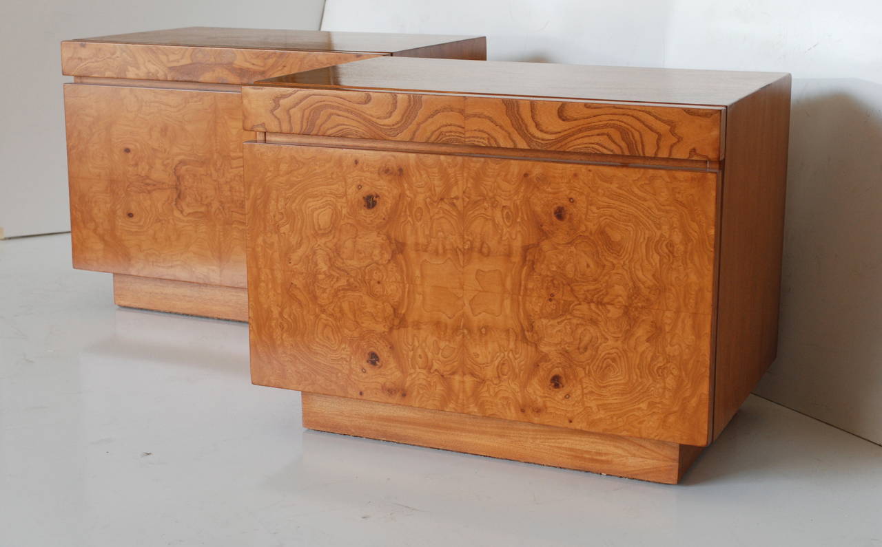 These pair of gently restored olive burl front nightstands have a pull-out shelf which is topped with a practical white laminate. The top and sides of the bedside tables are made of solid wood. The cabinets each have a single pull-out drawer for