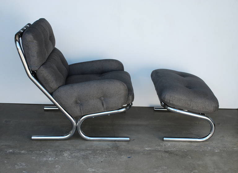 A soft felted grey fabric which harbors the feel of men's suiting has been used to recover this chair and ottoman.  It is in excellent condition and extremely comfortable. The ottoman size is 30