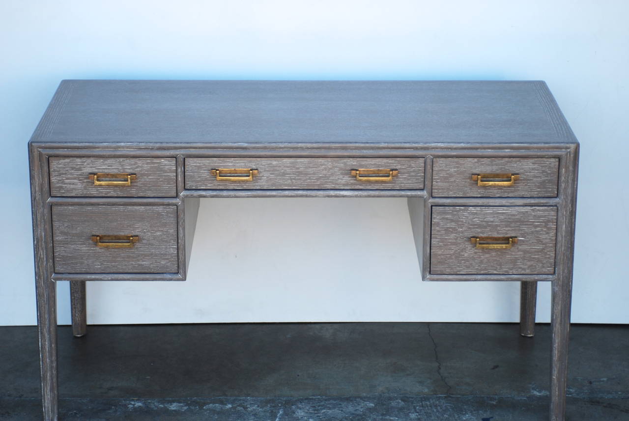 This elegant desk has been cerused in a soft taupe grey color that sets off the brass hardware beautifully. It is fully finished on the back so it can be floated in a room.