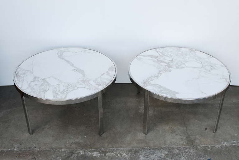 A beautiful pair of  high end custom calcutta marble and chrome side tables with chrome grommets in the marble handy for hiding lamp wires.