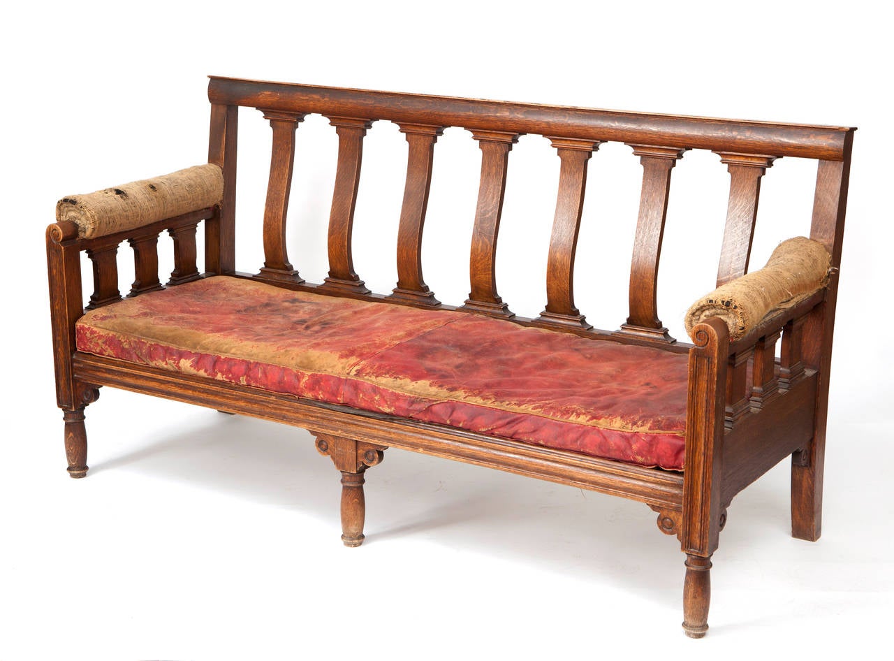 English oak and leather bench, circa 1860.
Wonderful original red leather and hessian arms.